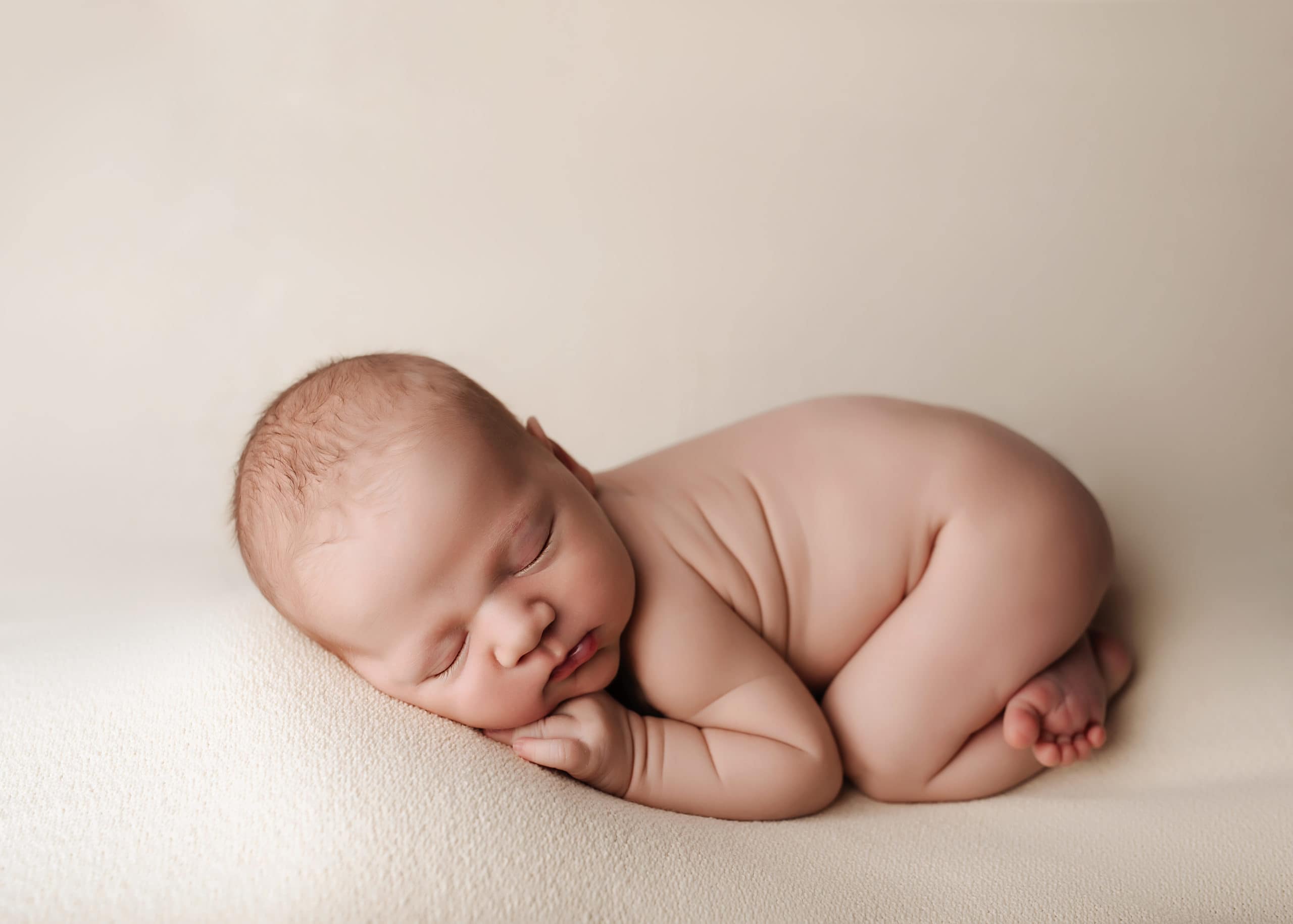 newborn baby curled up into squishy bum up pose for Prince George Newborn Session with Rayven Jade Photography