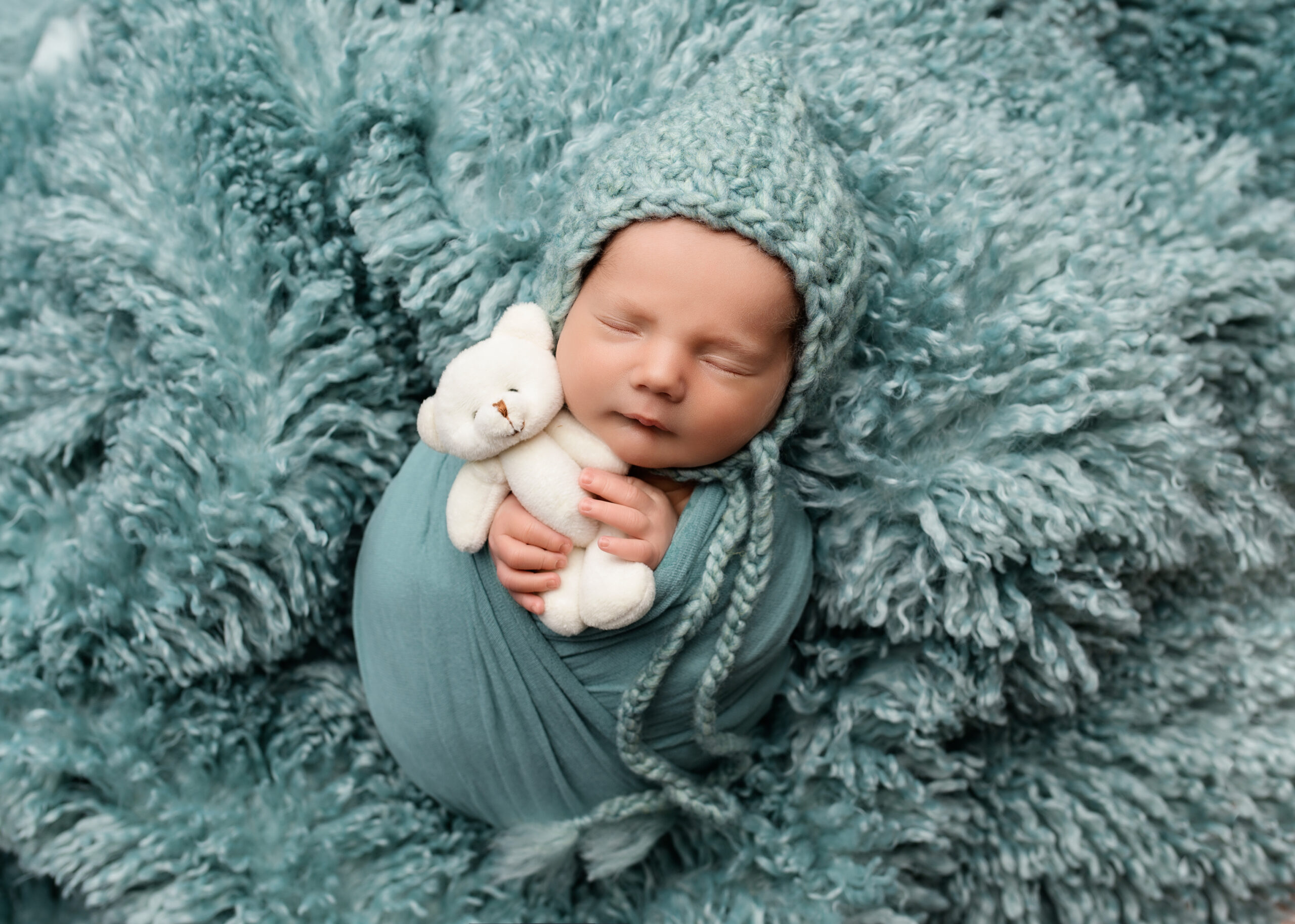 baby all wrapped up holding a tiny teddy bear, Prince George, BC, award winning photographer